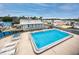 Community pool surrounded by lounge chairs and charming homes at 2011 Ketch Cir, Palm Harbor, FL 34683