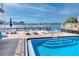 Community pool with waterfront view, blue umbrella, lounge chairs, and bench seating at 2011 Ketch Cir, Palm Harbor, FL 34683