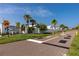 Community entrance with palms, landscaping, and a pathway at 2011 Ketch Cir, Palm Harbor, FL 34683