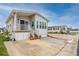 Charming home featuring a covered porch, paver driveway, and well-maintained landscaping at 2011 Ketch Cir, Palm Harbor, FL 34683