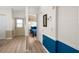 Hallway featuring wood-look floors, wainscoting, and a view into the bedroom with a blue bedspread at 2011 Ketch Cir, Palm Harbor, FL 34683