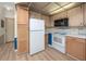 Bright kitchen with white appliances and wood cabinets, with blue panelling at 2011 Ketch Cir, Palm Harbor, FL 34683