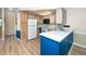 Bright kitchen featuring updated appliances, light wood cabinets, white countertop, and blue panels at 2011 Ketch Cir, Palm Harbor, FL 34683