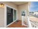 Inviting outdoor porch features wood flooring, sliding glass doors, and classic white railings at 2011 Ketch Cir, Palm Harbor, FL 34683