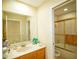 Well-lit bathroom with a single vanity, large mirror, and shower-tub combo at 2038 Oswego Dr, Holiday, FL 34691