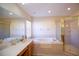 Bright bathroom featuring a tub, glass enclosed shower, and vanity with great lighting at 2038 Oswego Dr, Holiday, FL 34691