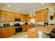 Efficient kitchen with wood cabinets, stainless steel appliances, and breakfast bar at 2038 Oswego Dr, Holiday, FL 34691