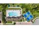 Aerial view showcasing community pool, tennis courts, bocce ball court, parking and meticulously landscaped grounds at 21008 Fetterbush Pl, Venice, FL 34293