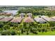 A beautiful aerial view of a residential community with well-maintained lawns, lake, and lush landscaping at 21008 Fetterbush Pl, Venice, FL 34293