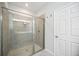 Modern bathroom featuring a glass-enclosed shower with tile surround at 21008 Fetterbush Pl, Venice, FL 34293