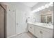 Bathroom featuring double vanity, framed mirror, and tiled shower at 21008 Fetterbush Pl, Venice, FL 34293