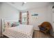 Bright bedroom featuring a comfortable bed, colorful pillows, and a cozy wicker chair at 21008 Fetterbush Pl, Venice, FL 34293