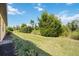 Side yard with well-maintained grass and mature landscaping providing privacy at 21008 Fetterbush Pl, Venice, FL 34293