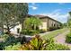 Landscaped exterior view showcasing lush greenery and a brick walkway leading to the home at 21008 Fetterbush Pl, Venice, FL 34293