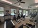 Well-equipped fitness center featuring treadmills, ellipticals, and weight training equipment overlooking the community pool at 21008 Fetterbush Pl, Venice, FL 34293