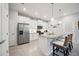 This white kitchen features stainless appliances, bar seating, and lots of natural light at 21008 Fetterbush Pl, Venice, FL 34293
