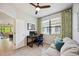 Bright and airy office space featuring a large window, modern decor, and a comfortable sofa at 21008 Fetterbush Pl, Venice, FL 34293