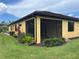 Screened patio, perfect for enjoying the outdoors with beautiful landscaping and well-maintained green grass at 21008 Fetterbush Pl, Venice, FL 34293