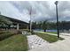 Community tennis court featuring well-maintained landscaping, seating, and an American flag at 21008 Fetterbush Pl, Venice, FL 34293