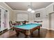 An inviting game room boasts a classic blue felt pool table, elegant light fixtures, and stylish seating at 2171 Portofino Pl # 27-2725, Palm Harbor, FL 34683