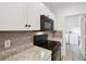 Close-up of a modern kitchen with stainless steel appliances, and granite countertops, adjacent to a laundry room at 2171 Portofino Pl # 27-2725, Palm Harbor, FL 34683