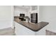 Modern kitchen with stainless steel appliances, white cabinets, and a breakfast bar with dark countertops at 2171 Portofino Pl # 27-2725, Palm Harbor, FL 34683