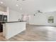 Bright living room with white walls, wood-look floors, ceiling fan, and natural light from a large window at 2171 Portofino Pl # 27-2725, Palm Harbor, FL 34683