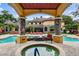 Beautiful community pool with a spa, gazebo, and seating with lush landscaping and beautiful building views at 2171 Portofino Pl # 27-2725, Palm Harbor, FL 34683