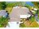 Aerial view of a home with a well-maintained roof, lush landscaping, and a screened porch at 2211 Harrison Dr, Holiday, FL 34691