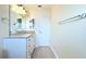 Bright bathroom with a double sink vanity featuring a granite countertop and tile flooring at 2211 Harrison Dr, Holiday, FL 34691