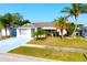 Charming single-story home with lush landscaping, well-manicured lawn and a blue driveway at 2211 Harrison Dr, Holiday, FL 34691