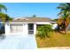 Well-maintained one-story home with mature palm trees and lush landscaping at 2211 Harrison Dr, Holiday, FL 34691