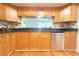 Charming kitchen with granite counters, wood cabinets, and stainless steel dishwasher at 2211 Harrison Dr, Holiday, FL 34691