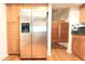 Kitchen featuring stainless steel refrigerator, wood cabinets, and wood floors at 2211 Harrison Dr, Holiday, FL 34691