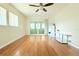 Spacious living room with hardwood floors, fan and sliding glass door to sunroom at 2211 Harrison Dr, Holiday, FL 34691