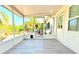 Cozy screened porch with wood look flooring and a view of the yard at 2211 Harrison Dr, Holiday, FL 34691