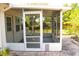 Enclosed screened porch featuring a pet door, white rocking chair, and brick pavers at 2211 Harrison Dr, Holiday, FL 34691