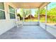 Relaxing screened porch featuring a white chair and vinyl flooring at 2211 Harrison Dr, Holiday, FL 34691