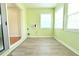 A sunny sunroom with wood-look floors and bright green walls with multiple windows at 2211 Harrison Dr, Holiday, FL 34691