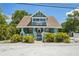 Inviting beach house featuring lush landscaping, a gabled roof, and signage, making it a Gathering-friendly accommodation at 224 Georgia Ave, Crystal Beach, FL 34681
