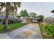 Cozy home featuring a covered carport and lush landscaping, providing shade and curb appeal at 224 Georgia Ave, Crystal Beach, FL 34681