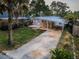 Inviting single-story home with a carport, surrounded by lush landscaping and a spacious front yard at 224 Georgia Ave, Crystal Beach, FL 34681