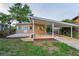 Cozy one-story home featuring a covered carport and well-manicured lawn with vibrant floral accents at 224 Georgia Ave, Crystal Beach, FL 34681