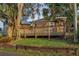Landscaped yard with a wooden deck and mature trees offering shade and privacy at 224 Georgia Ave, Crystal Beach, FL 34681