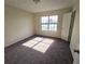 Sunlit bedroom with neutral walls, new carpet, and a window overlooking the front yard at 2302 Maki Rd # 2, Plant City, FL 33563