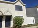 Two-story home with cream siding, dark blue door, and a garden with red flowers in front at 2302 Maki Rd # 2, Plant City, FL 33563