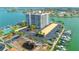 Aerial view of a waterfront condo building with parking, landscaping, and boat docks at 240 Sand Key Estates Dr # 243, Clearwater Beach, FL 33767