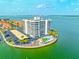 Aerial view of a waterfront condo building with pool, parking, landscaping, and boat docks at 240 Sand Key Estates Dr # 243, Clearwater Beach, FL 33767