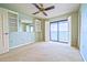 Bedroom with a ceiling fan, shelves, and sliding glass doors to a balcony with water views at 240 Sand Key Estates Dr # 243, Clearwater Beach, FL 33767