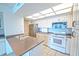 Bright, updated kitchen with white cabinetry, stainless steel appliances, and ample counter space at 240 Sand Key Estates Dr # 243, Clearwater Beach, FL 33767